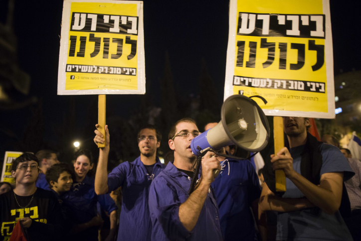 Israelis hold up signs and chant slogans as they take part in a protest march against Finance Minister Yair Lapid and the state budget in central Jerusalem, on May 18, 2013. Thousands of Israelis took to the streets on Saturday evening to protest against the government's planned austerity measures. Photo by Yonatan Sindel/Flash90 *** Local Caption *** ???? ????? ???? ???? ????? ???? ?????? ??????? ??? ????? ????? ????? ???? ??????